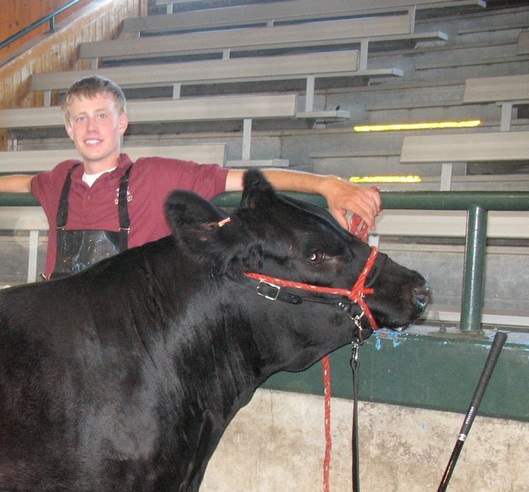 Nick Van Engen as a teenager, standing with a Simmental steer at a junior cattle show in 2010.